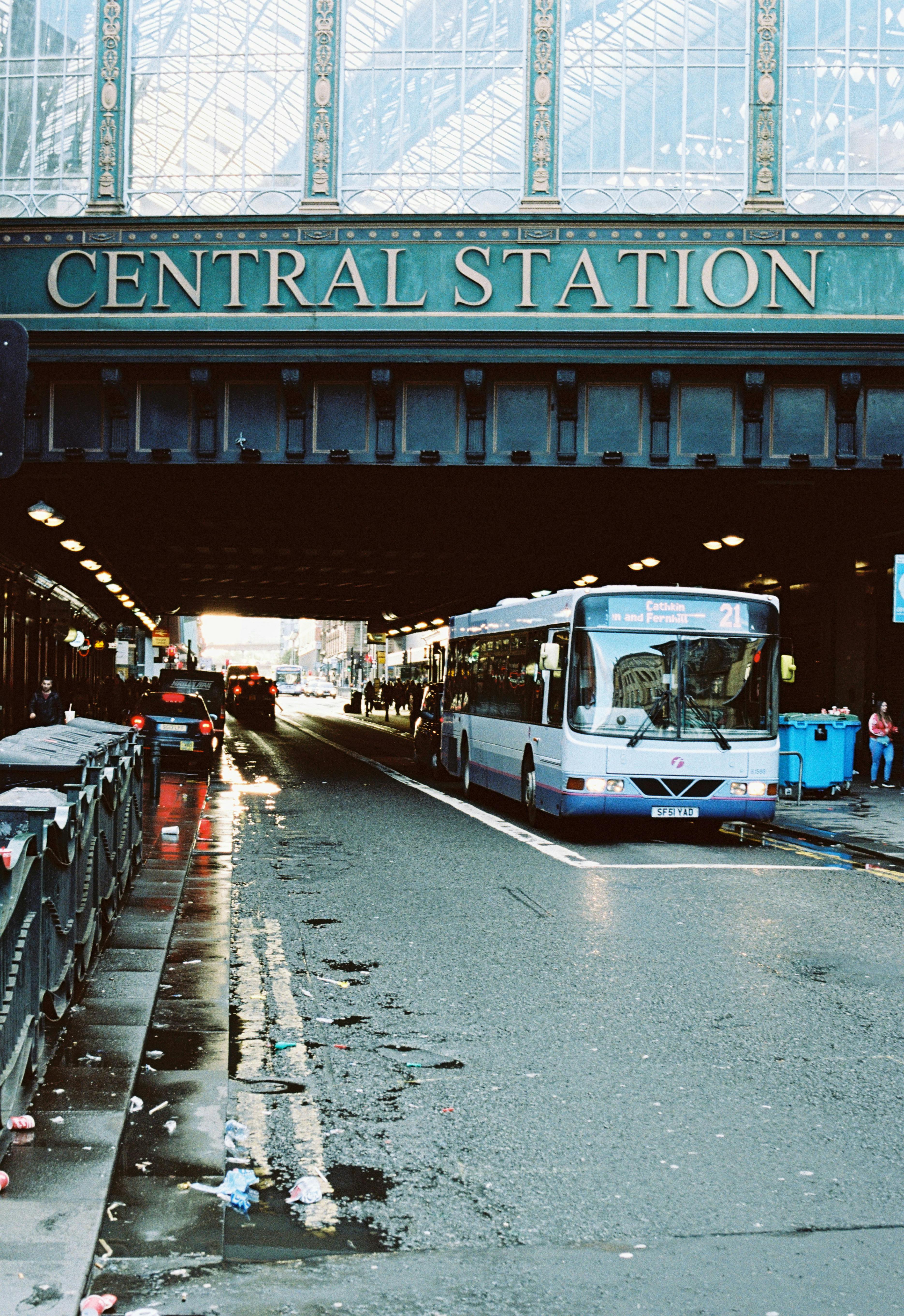 Bus at Central Station under historic stone archway with railway signage